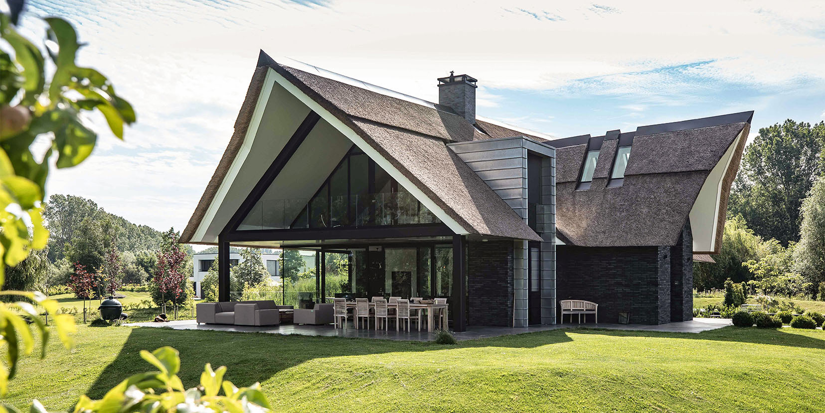 Luxe villa met rieten dak en uniek daklandschap.