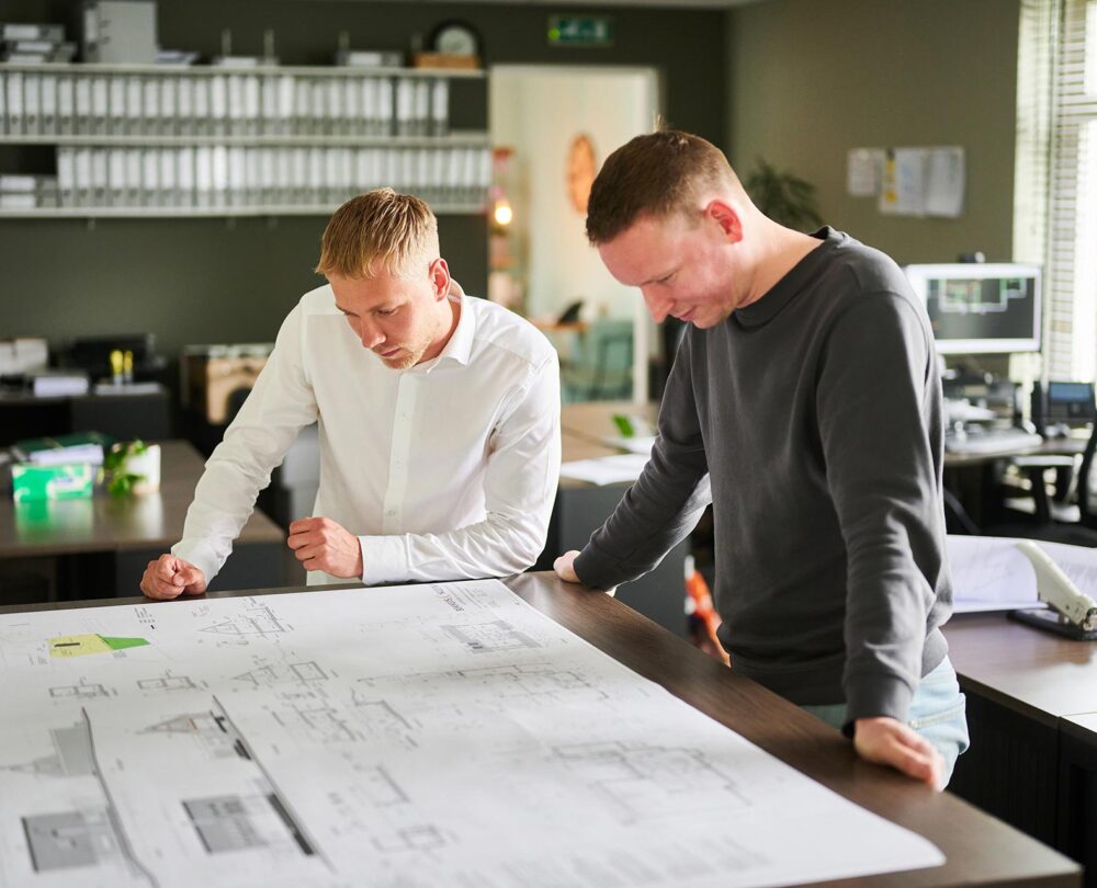 Bekhuis & Kleinjan kantoor twee mannen die aan het kijken zijn naar een bouwtekening
