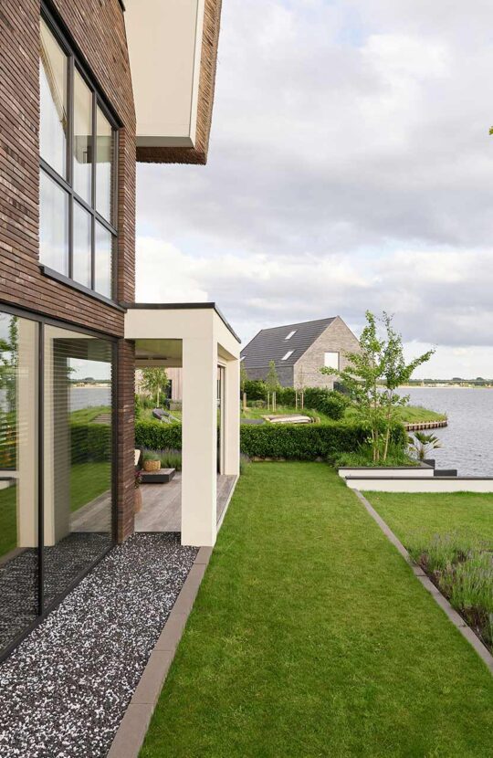 Luxe villa Meerstad achtertuin met uitzicht op het water