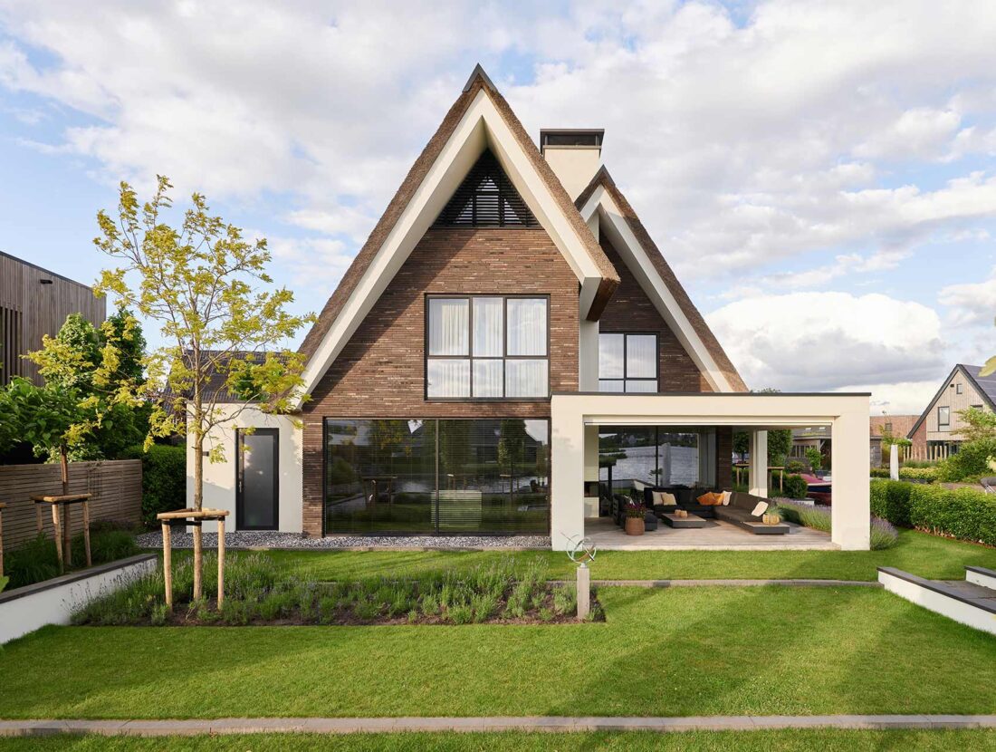 Achterkant van een luxe villa, met donkere stenen, ontworpen door Bekhuis & KleinJan