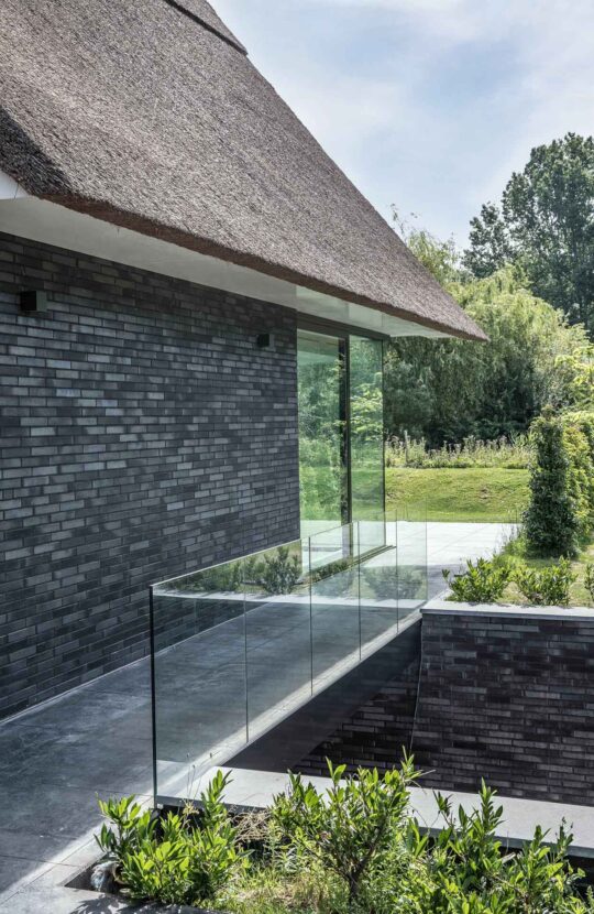 Luxe villa Lelystad met donkere stenen en een rieten kap