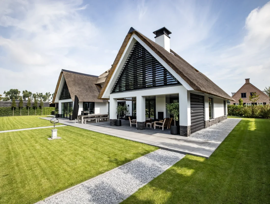 Moderne landelijke villa met rietgedekt dak en veranda