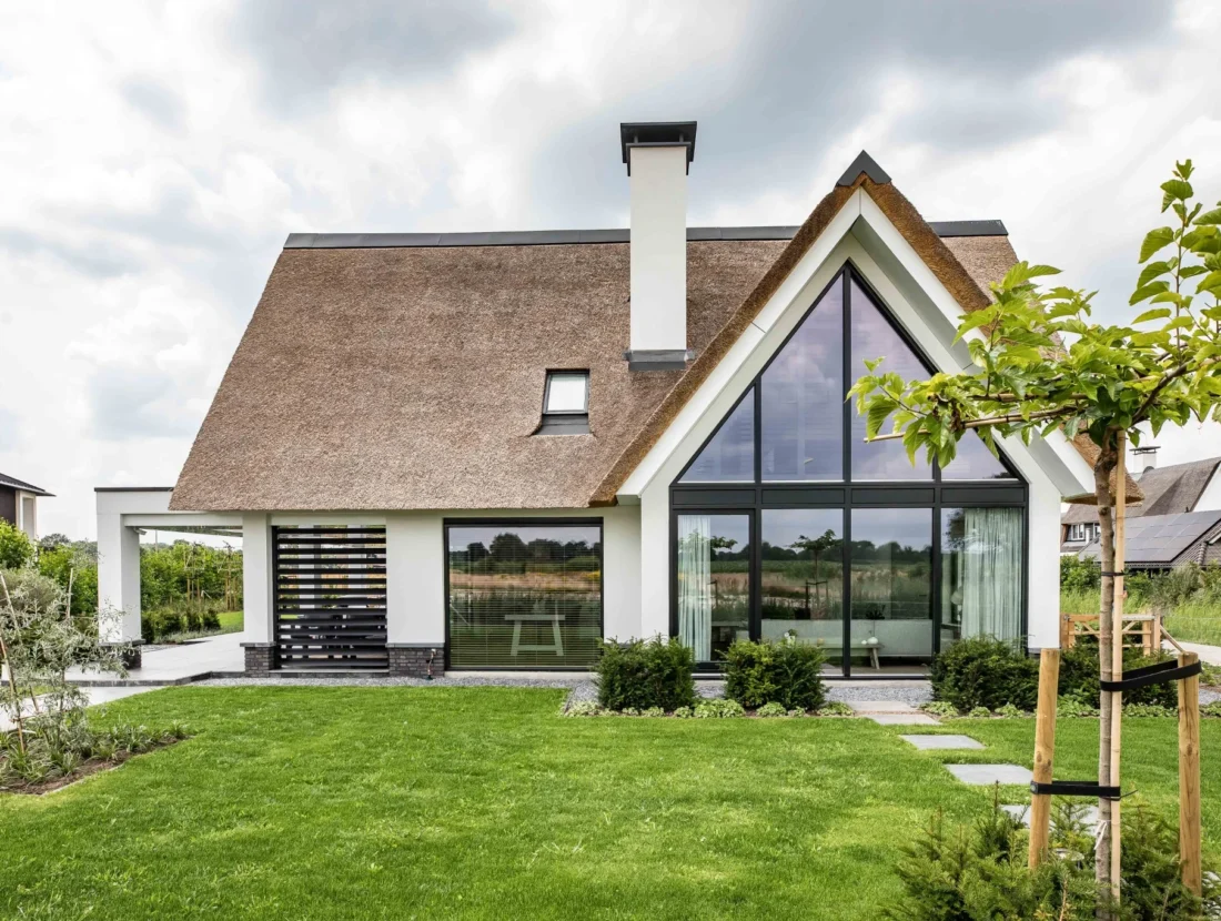 Moderne landelijke villa met rieten kap en grote raampartijen