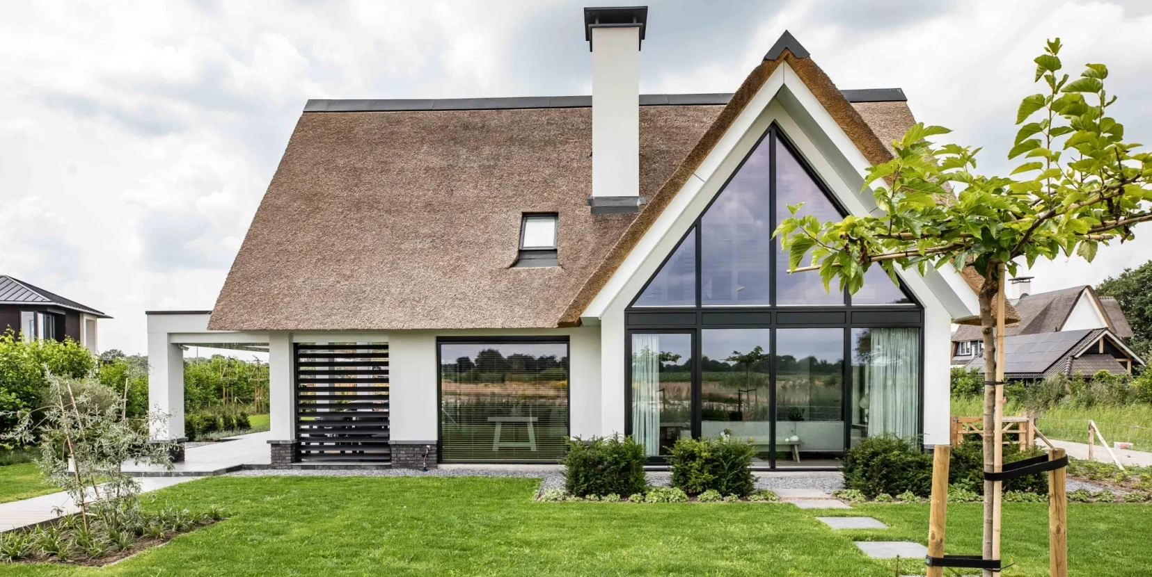 Moderne landelijke villa met rieten kap en grote raampartijen
