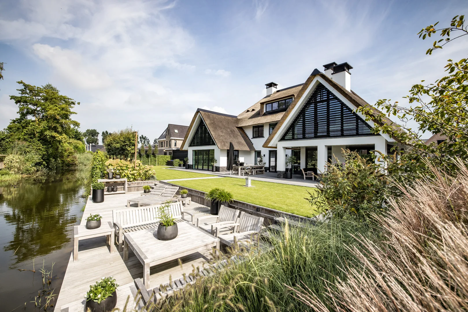 Villa met rieten dak en zwarte lamellen, ontworpen door Bekhuis & KleinJan.