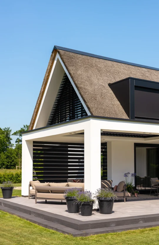 Moderne overkapping bij een villa met rieten kap, ontworpen door Bekhuis & KleinJan