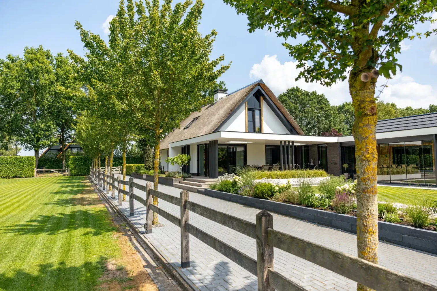 Rietgedekte maatwerkwoning vanuit de tuin gefotografeerd