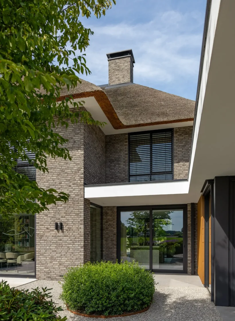 Details van een klassieke woning, je ziet metselwerk en raampartijen